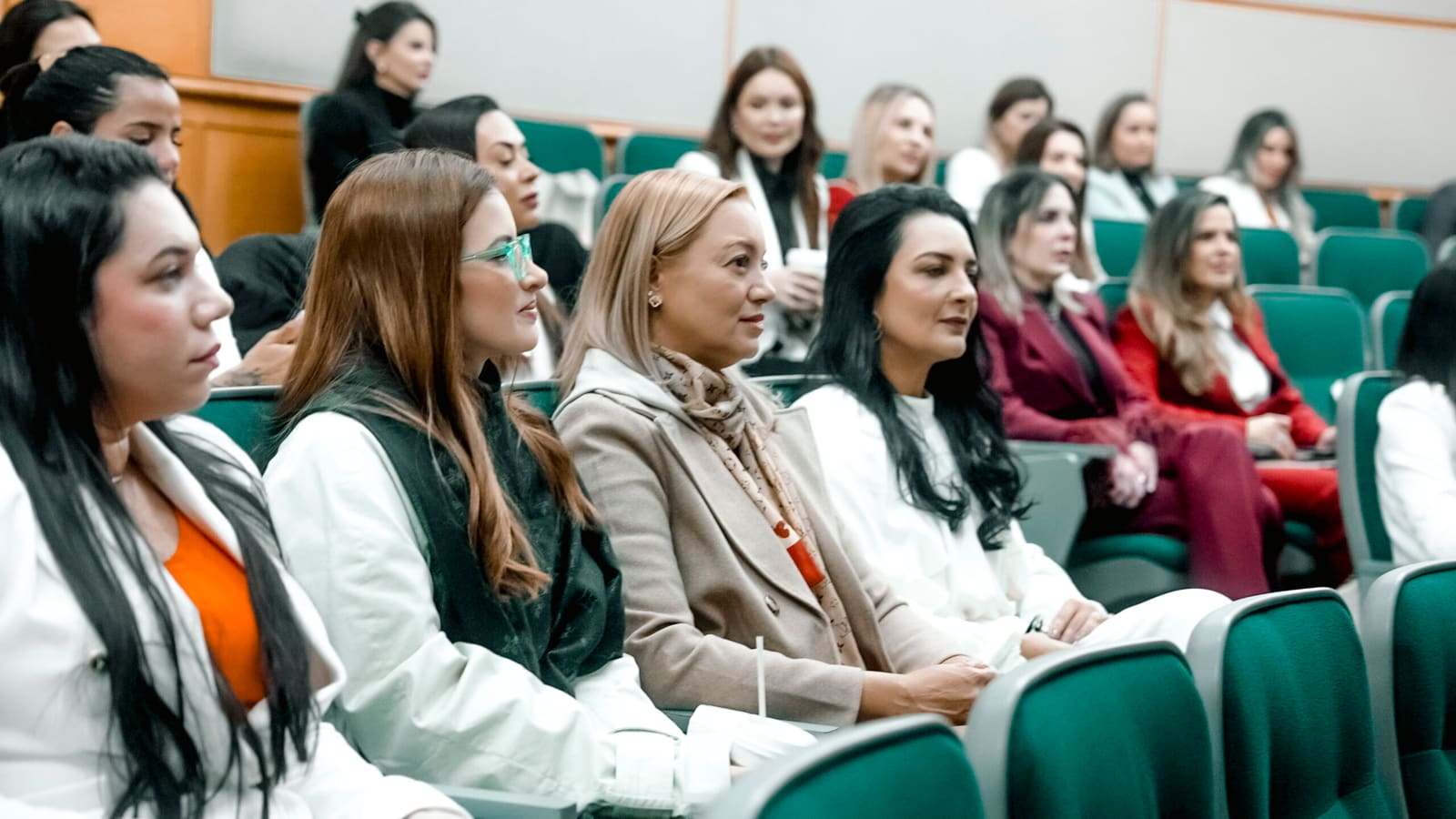 Profissionais de Saúde Estética assistindo a sessão executiva em auditório acadêmico em Boston.